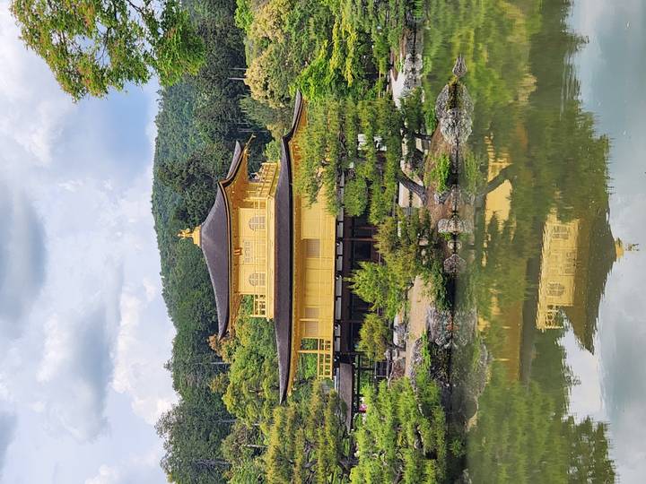 Golden Pavilion (Kinkaku-ji) reflected in a tranquil pond surrounded by greenery