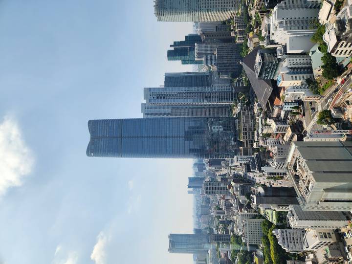 Modern Tokyo skyline dominated by a sleek glass skyscraper on a bright day