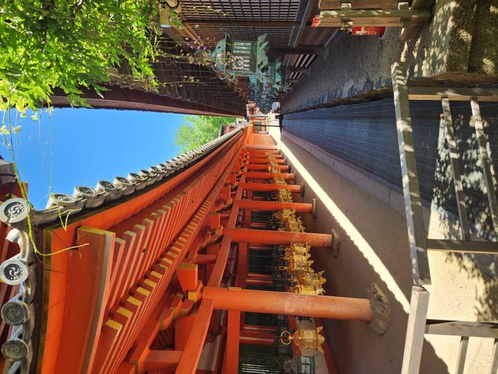 Red-pillared corridor of Kasuga Taisha shrine adorned with hanging bronze lanterns