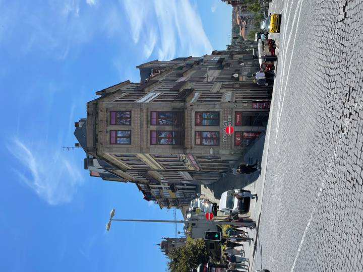 Steep cobbled street in Porto lined with tall colourful townhouses beneath a bright blue sky.