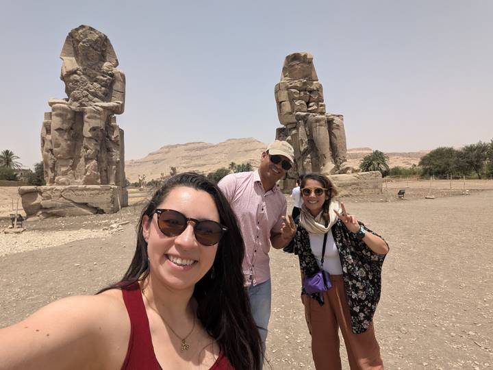 Three friends take a selfie in front of the colossal seated statues of the Colossi of Memnon.