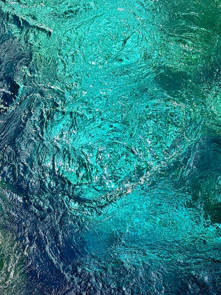 Vivid turquoise swirling waters of Albania’s Blue Eye spring captured from above.