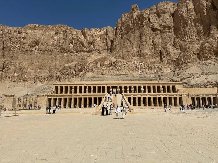 Impressive terraced façade of Hatshepsut’s mortuary temple set against towering desert cliffs.