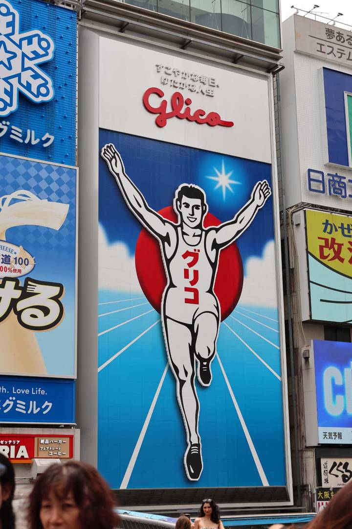 Iconic Glico running-man billboard set against a vivid graphic background