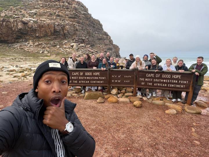Group selfie at Cape of Good Hope sign marking southwestern tip of Africa