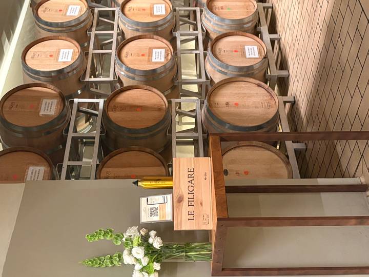 Rows of oak wine barrels line a cellar at Le Filigare winery in Tuscany.