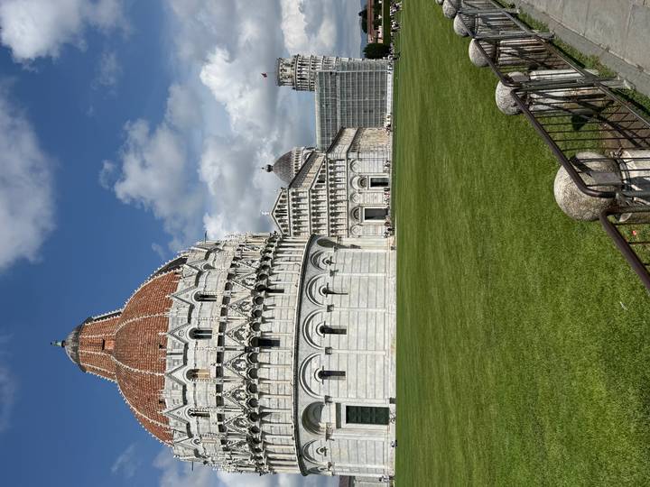 Expansive view of Pisa's Baptistery and Cathedral on a bright day.