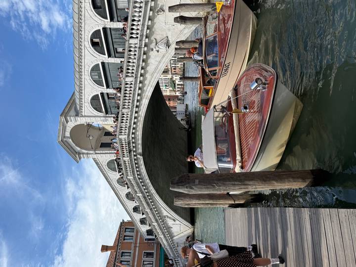 Motorboats docked near the iconic Rialto Bridge spanning the Grand Canal.