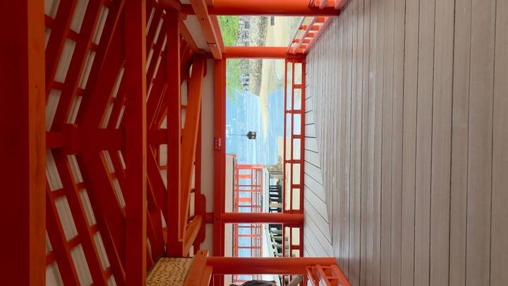 Vibrant red covered corridor of Itsukushima Shrine looking out to the sea