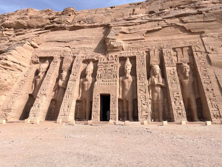 Rock-cut façade of Abu Simbel’s smaller temple displaying large standing statues carved into the cliff.