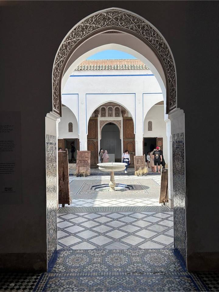 Intricate tiled courtyard with a central fountain and carved wooden doors inside Bahia Palace