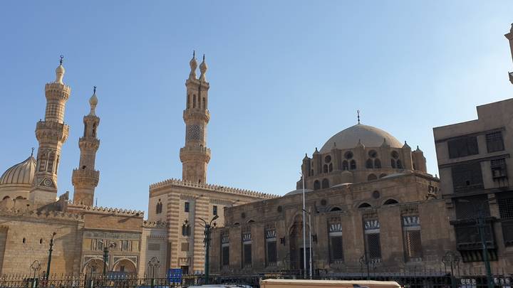 Panoramic view of Al-Azhar Mosque complex with multiple minarets under a clear sky.