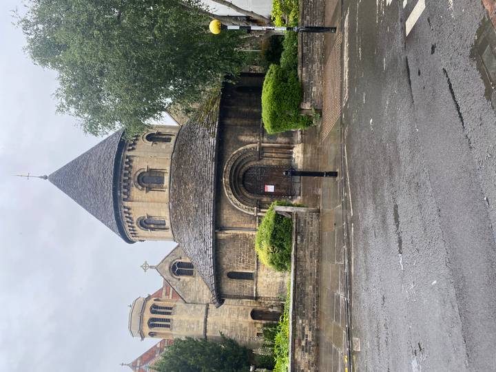 Historic round church built of stone under light rain in Cambridge.
