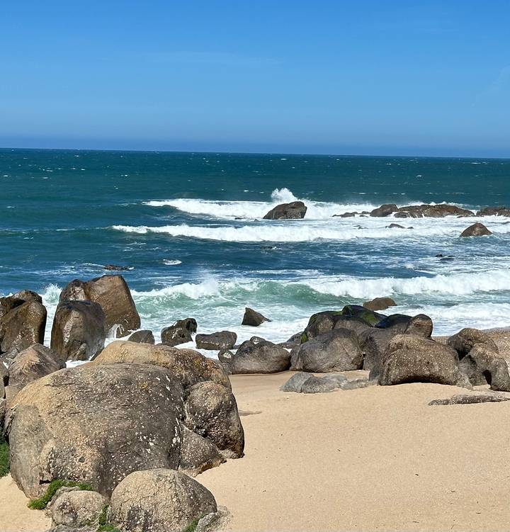 Rocky Atlantic shoreline with crashing waves and deep blue sea.