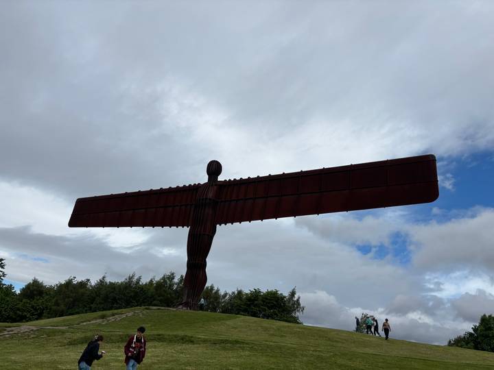 Silhouette of the massive Angel of the North steel sculpture against a cloudy sky.