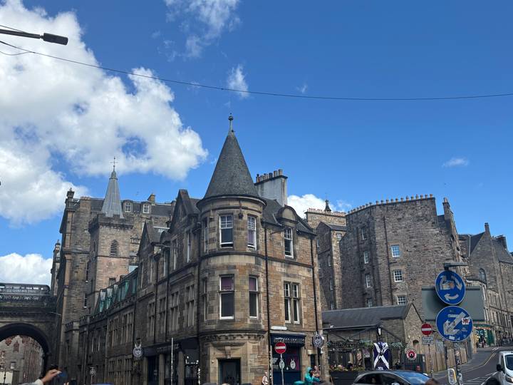 Stone and brick Victorian buildings of Edinburgh’s Old Town beneath a bright blue sky.