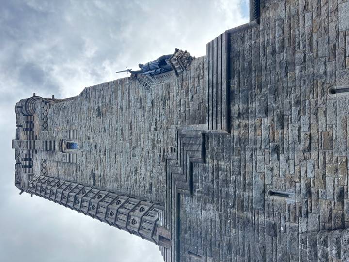Stone wall of the Wallace Monument shot from below with a carved knight statue on a ledge.
