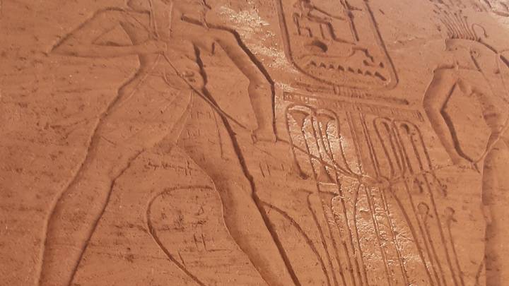 Close-up of ancient Egyptian hieroglyphic relief carving etched into sandstone.