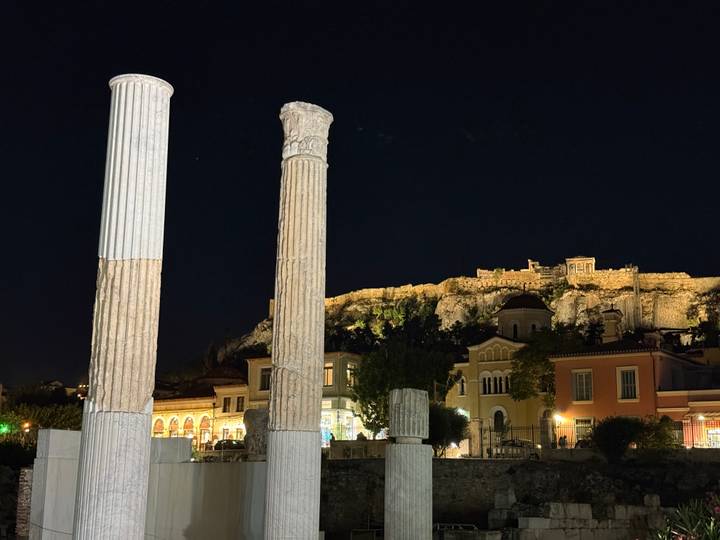 Night view of classical columns with the Acropolis hill lit in the background