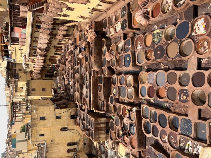 Birds-eye view of Fes tannery with numerous stone vats filled with dyes and hides.