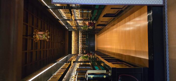 Dimly lit temple interior with polished wooden floor and rows of ornate golden memorial tablets