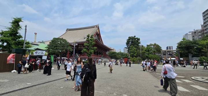 Busy courtyard of Senso-ji Temple filled with visitors under a bright sky