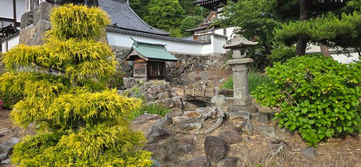 Zen-style rock and shrub garden featuring stone lantern and small bridge