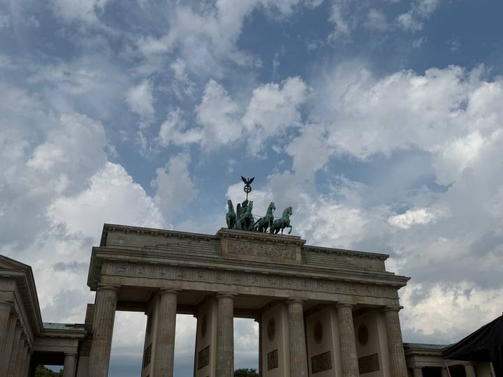 Upward view of the Brandenburg Gate’s quadriga set against a partly cloudy blue sky