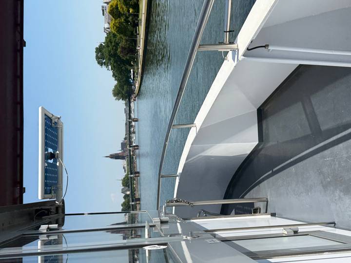 View from a riverboat deck looking toward Frankfurt’s skyline with a cathedral spire and bridges over the Main
