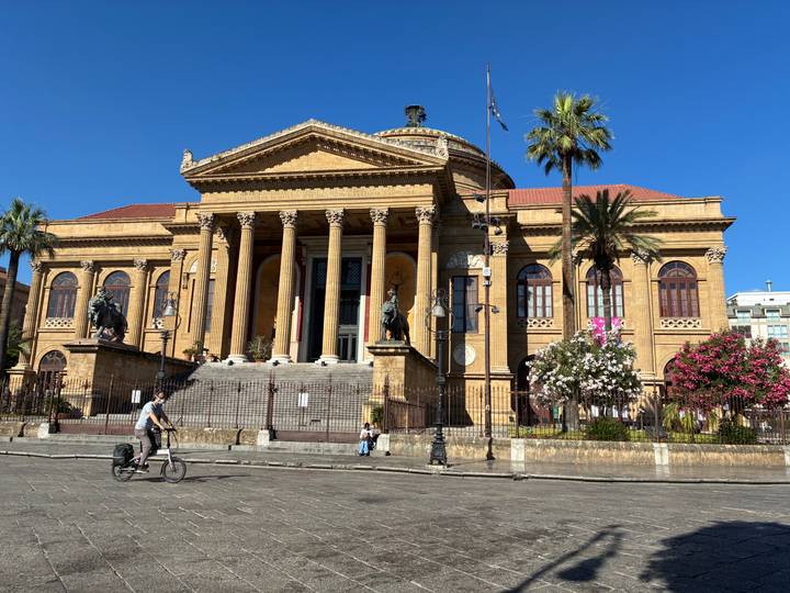 Grand neoclassical Teatro Massimo in Palermo with columns and statues under a clear blue sky