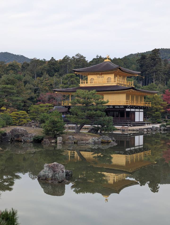 Golden Pavilion (Kinkaku-ji) reflected in a tranquil pond amid autumn trees in Kyoto.