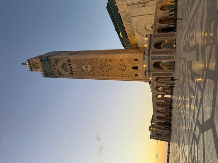 Majestic Hassan II Mosque minaret rises above expansive marble plaza at dusk in Casablanca