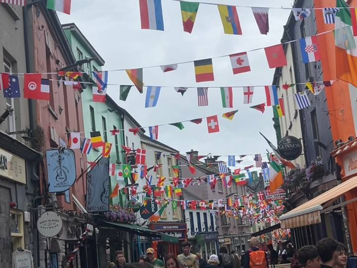 Colorful European street lined with flags from many countries hanging overhead