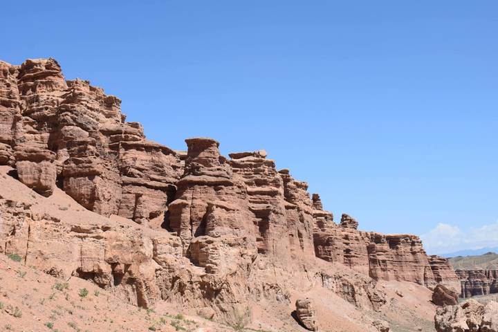 Red sandstone formations of Charyn Canyon towering against bright blue Kazakh sky