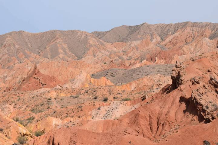 Colorful eroded hills and ridges of Fairytale Canyon near Issyk Kul under hazy sky