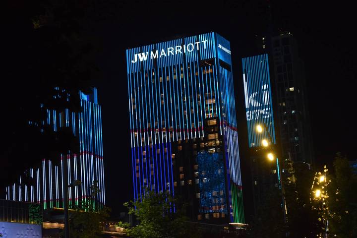 Night view of illuminated JW Marriott skyscraper with colorful LED stripes in Tashkent