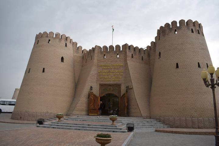 Historic Ark Fortress entrance in Bukhara with tall mud-brick walls under blue sky