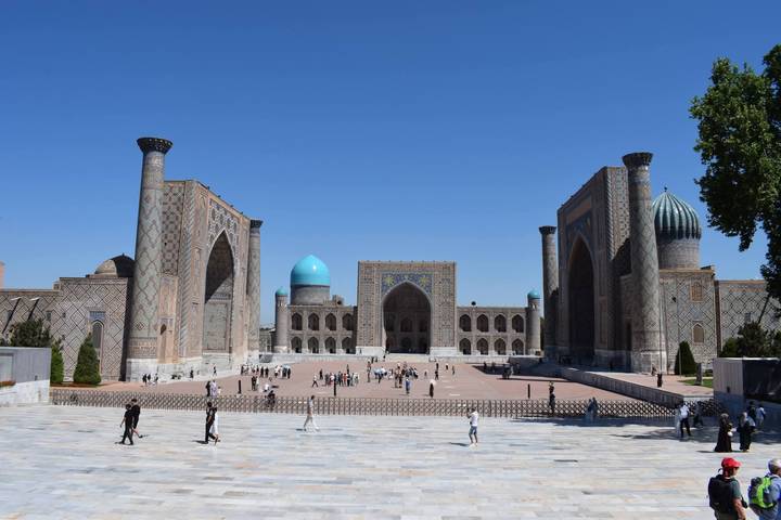 Registan square in Samarkand with three grand madrasas and turquoise domes under clear blue sky