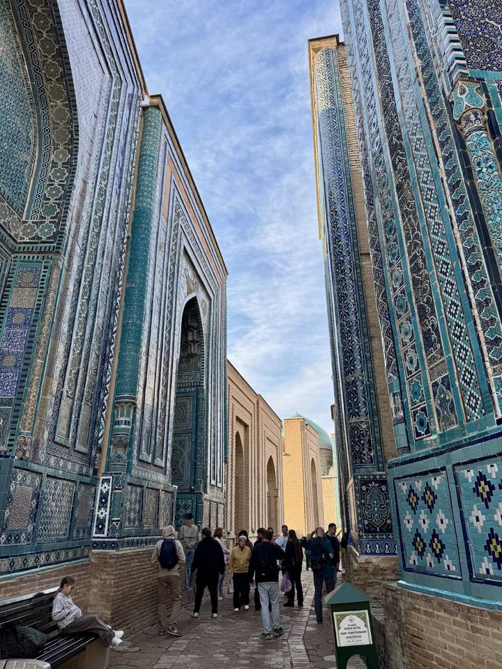 Narrow alley of Shah-i-Zinda necropolis lined with ornate blue-tiled mausoleums in Samarkand.
