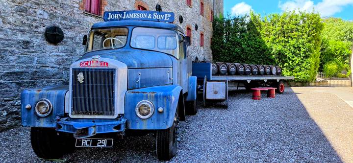 Vintage blue Scammell truck and flatbed with whiskey barrels outside the Jameson distillery.