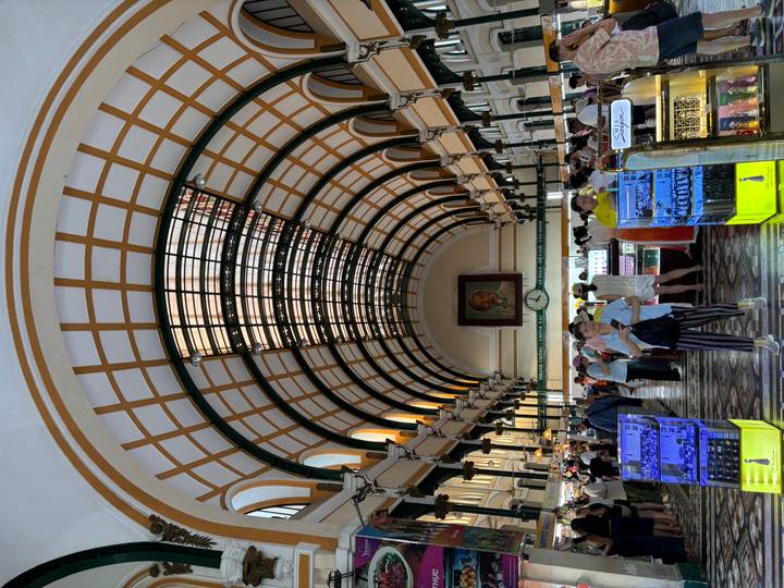Bustling interior of Ho Chi Minh City’s French colonial Central Post Office with arched glass roof.
