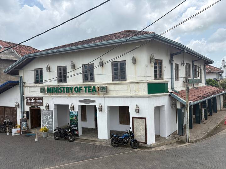 Colonial-era two-storey building labeled 'Ministry of Tea' on a narrow street corner.