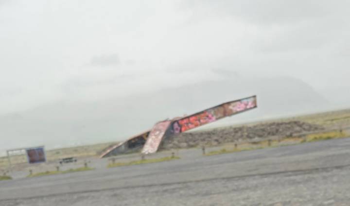 Tilted, blurry image of a graffiti-covered ramp in a foggy, featureless plain