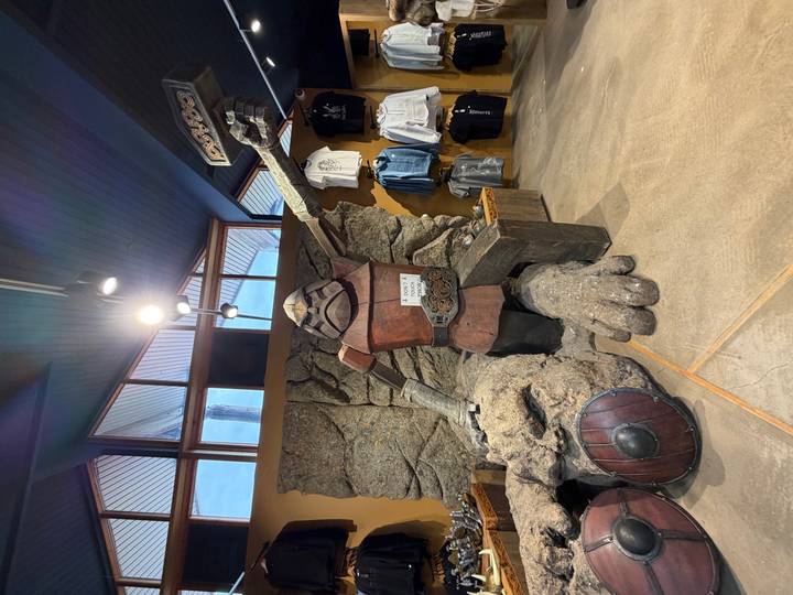 Indoor shop display featuring a large troll statue with shields and Icelandic themed souvenirs