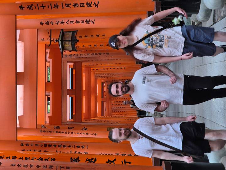 Travellers walk through the famous vermilion torii tunnel at Fushimi Inari Shrine.