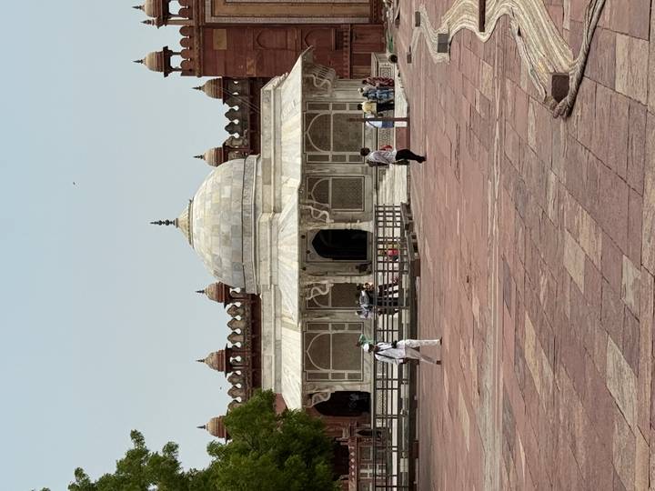Marble tomb of Salim Chishti in Fatehpur Sikri courtyard with a few visitors strolling.
