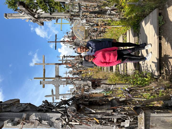 Couple stands among hundreds of wooden crosses at the famous Hill of Crosses pilgrimage site.