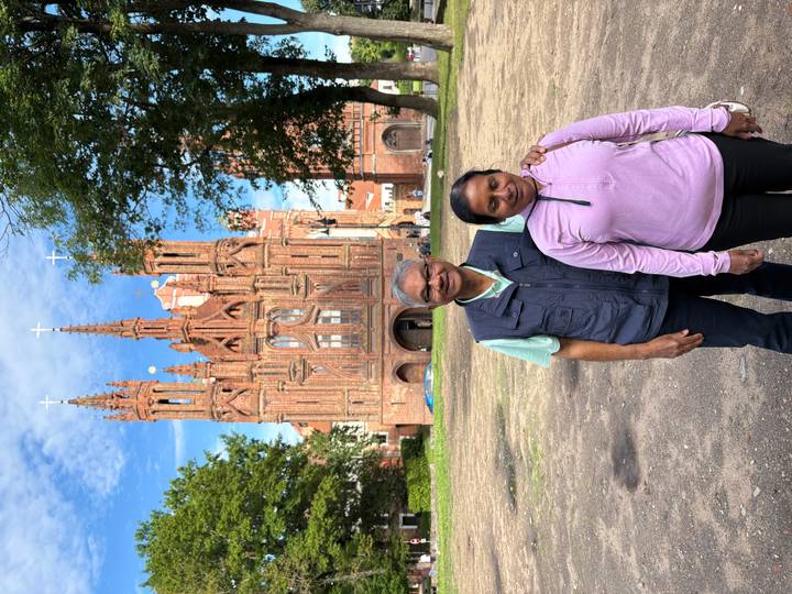 Travellers pose before the ornate red brick St. Anne's Church in Vilnius.