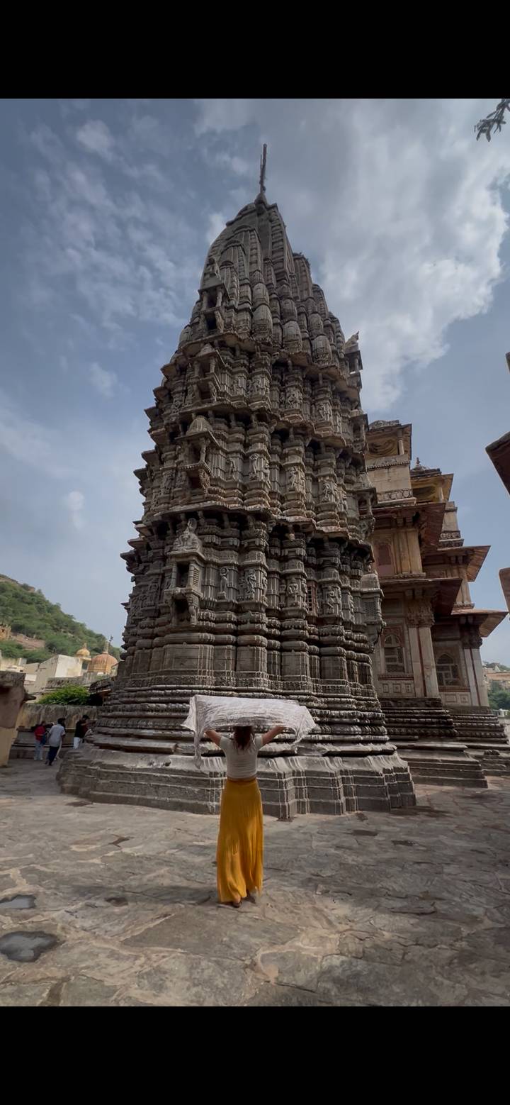 Close view of intricately carved stone temple tower with layered sculptural details.