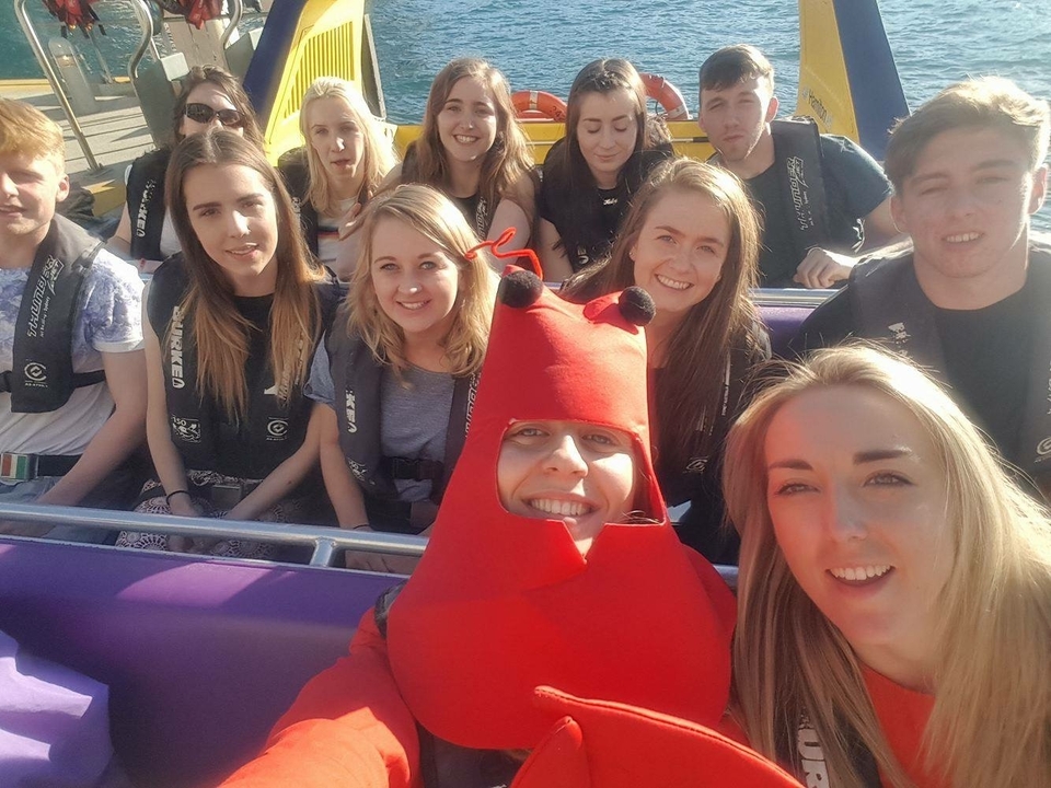 Group selfie on a ride, one person in a lobster costume.